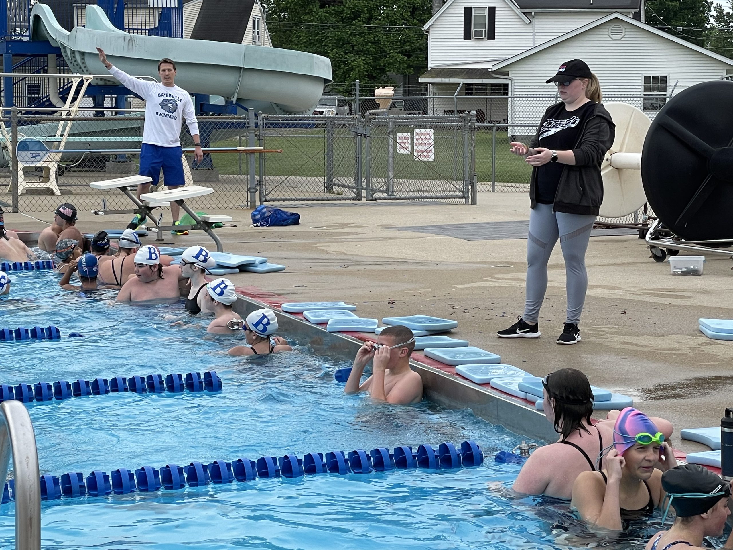 Swimmers listening to a coach give instruction